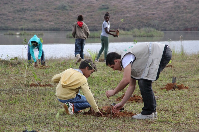 Estudantes plantam mudas de árvores na área de reflorestamento da Represa João Penido